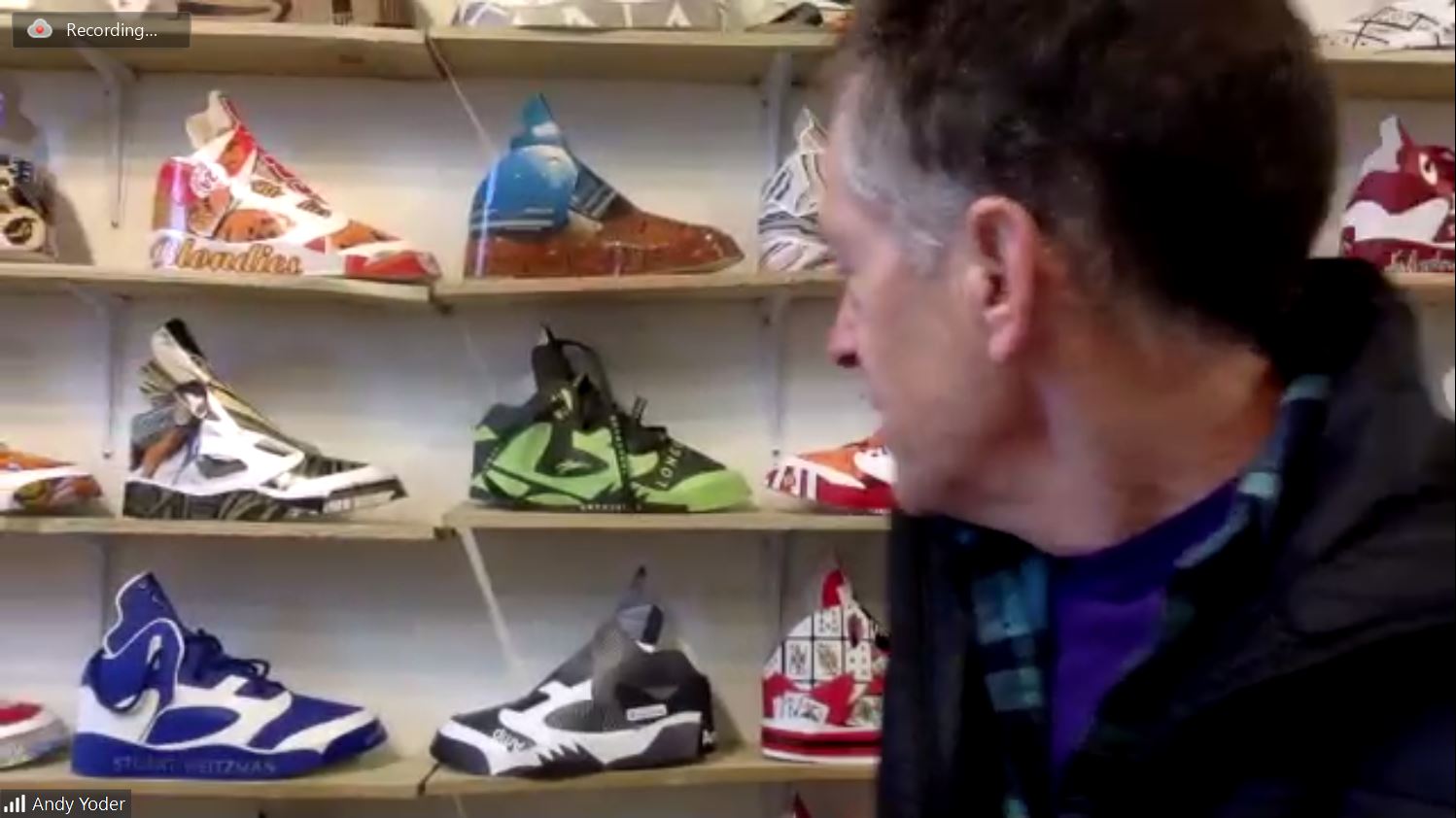Man Speaking in front of shoe collection